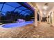 Large screened pool with waterfall feature, lounge chairs, dining table, and ceiling fans at 19711 Wellington Manor Blvd, Lutz, FL 33549