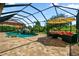 Screened in pool with waterfall feature, lounge chairs and covered seating area at 19711 Wellington Manor Blvd, Lutz, FL 33549