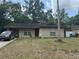 Tan single-story home with a brown front door and two windows, and a car parked in the driveway at 201 Lentz Rd, Brandon, FL 33510