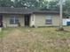 Tan single-story home with a brown front door and two windows, with a large palm tree in the front yard at 201 Lentz Rd, Brandon, FL 33510