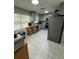 An all-grey kitchen features stainless steel appliances, gray cabinets, and a window with blinds at 201 Lentz Rd, Brandon, FL 33510