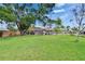 Large, grassy backyard featuring a patio with outdoor grilling area, offering ample space for recreation and relaxation at 206 4Th Nw Ave, Ruskin, FL 33570