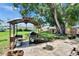 Spacious backyard featuring an outdoor grilling area, lush green grass, and mature tree, ideal for outdoor living at 206 4Th Nw Ave, Ruskin, FL 33570