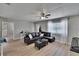 Bright living room featuring hardwood floors, a leather sofa, and a modern ceiling fan at 206 4Th Nw Ave, Ruskin, FL 33570