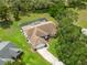 An aerial shot showing a house with a screened in pool surrounded by lush trees and green grass at 206 Forest Wood Ct, Spring Hill, FL 34609
