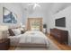 Stylishly furnished bedroom with hardwood floors, neutral tones, and a sliding glass door to the backyard at 206 Forest Wood Ct, Spring Hill, FL 34609