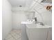 Bright laundry room features tile floors, laundry sink, washer and dryer hookups and wire shelving for storage at 206 Forest Wood Ct, Spring Hill, FL 34609