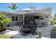 Outdoor dining area with shaded umbrella perfect for entertaining in the landscaped backyard at 2271 Carolyn Dr, Dunedin, FL 34698