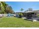 Spacious backyard showcasing a lush lawn, patio, outdoor dining, and privacy fence at 2271 Carolyn Dr, Dunedin, FL 34698