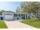 Charming single-story home with a well-manicured lawn and an attached garage on a sunny day at 2271 Carolyn Dr, Dunedin, FL 34698