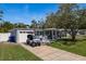Charming single-story home featuring a well-manicured lawn, mature tree, and a one-car garage at 2271 Carolyn Dr, Dunedin, FL 34698