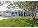 Charming single-story home with a well-manicured lawn, white rock landscaping, and inviting front porch seating at 2271 Carolyn Dr, Dunedin, FL 34698