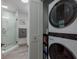 Convenient laundry area featuring a stacked washer and dryer, and adjacent bathroom with a glass-enclosed shower at 2271 Carolyn Dr, Dunedin, FL 34698