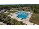 Aerial view of a large outdoor pool with swimming lanes, diving boards, and sunbathing areas with lounge chairs and umbrellas at 2271 Carolyn Dr, Dunedin, FL 34698