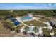 Aerial view of a community pool area featuring palm trees, lounge chairs, and a smaller pool at 2271 Carolyn Dr, Dunedin, FL 34698