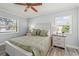 A primary bedroom with hardwood floors, ceiling fan, and two windows at 2334 Tropical Shores Se Dr, St Petersburg, FL 33705