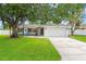 Charming single-story home with an attached garage, lush green lawn and mature shade tree at 2334 Tropical Shores Se Dr, St Petersburg, FL 33705