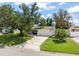 Well-maintained single-story home with green lawn, mature trees, and paved driveway at 2334 Tropical Shores Se Dr, St Petersburg, FL 33705