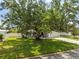 Well-maintained single-story home with green lawn, mature trees, and paved driveway at 2334 Tropical Shores Se Dr, St Petersburg, FL 33705