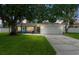 Charming single-story home with an attached garage, lush green lawn and mature shade tree at 2334 Tropical Shores Se Dr, St Petersburg, FL 33705
