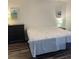 Bright bedroom with wood-look floors, dresser and beach-themed artwork at 240 N Bayshore Blvd # 102, Clearwater, FL 33759