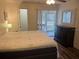 Bedroom with ceiling fan, mirror, dark dresser, and sliding glass door to outdoor patio at 240 N Bayshore Blvd # 102, Clearwater, FL 33759