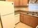 Functional kitchen includes wood cabinets, a stainless steel sink, and a white refrigerator at 240 N Bayshore Blvd # 102, Clearwater, FL 33759