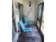 Relaxing screened patio with slate tile floor, features two inviting blue chairs and a small table at 240 N Bayshore Blvd # 102, Clearwater, FL 33759