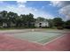 Well-maintained tennis court surrounded by lush greenery and charming residential architecture in a sports community at 240 N Bayshore Blvd # 102, Clearwater, FL 33759