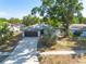 Inviting single-story home boasts a neatly manicured lawn, mature trees, and a convenient two-car garage at 2436 Beacon Groves Blvd, Palm Harbor, FL 34683