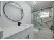 Modern bathroom featuring a vanity sink and tub with glass enclosure at 2436 Beacon Groves Blvd, Palm Harbor, FL 34683