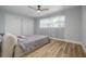 Bright, spacious bedroom with modern ceiling fan, closet and light-colored wood grain flooring at 2436 Beacon Groves Blvd, Palm Harbor, FL 34683
