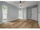 This bedroom features a ceiling fan, windows, and wood-look floors at 2436 Beacon Groves Blvd, Palm Harbor, FL 34683