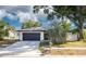 Charming single-story home with a well-maintained lawn, mature trees, and a two-car garage at 2436 Beacon Groves Blvd, Palm Harbor, FL 34683