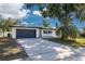 Charming single-story home with a well-maintained lawn, mature trees, and a two-car garage at 2436 Beacon Groves Blvd, Palm Harbor, FL 34683