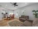 Well lit open concept living room with adjacent dining space featuring new windows and modern ceiling fan at 2436 Beacon Groves Blvd, Palm Harbor, FL 34683