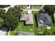 A peaceful aerial view of a house with a lush green lawn, nearby trees, and a neighboring pool at 2803 Abbey Grove Dr, Valrico, FL 33594