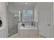 This bathroom features a glass shower, a soaking tub, and a large window at 2803 Abbey Grove Dr, Valrico, FL 33594