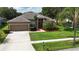 Charming single-Gathering home boasts lush landscaping, mature trees, and a welcoming front entrance at 2803 Abbey Grove Dr, Valrico, FL 33594