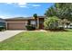 Charming single-story home with a well-manicured lawn, mature trees, and a welcoming front entrance at 2803 Abbey Grove Dr, Valrico, FL 33594