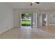 Open living room with tile floors and sliding doors offering views of the lush backyard at 2803 Abbey Grove Dr, Valrico, FL 33594