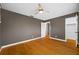 Bedroom with hardwood floors, a ceiling fan, and an open door leading to a room with stairs at 320 Tallahassee Ne Dr, St Petersburg, FL 33702