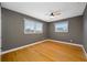 Bedroom features wood floors, two windows with blinds, a ceiling fan, and gray walls at 320 Tallahassee Ne Dr, St Petersburg, FL 33702