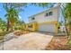 Charming two-story home with a spacious driveway, attached garage, and inviting walkway at 320 Tallahassee Ne Dr, St Petersburg, FL 33702