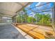 Spacious screened patio featuring wood flooring and views of the lush, tropical backyard at 320 Tallahassee Ne Dr, St Petersburg, FL 33702