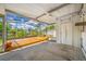 A spacious screened-in porch with a wooden deck, ceiling fan, and access to the backyard at 320 Tallahassee Ne Dr, St Petersburg, FL 33702