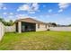 A sprawling backyard with green grass featuring a covered patio and white vinyl fencing at 3302 Granite Ridge Loop, Land O Lakes, FL 34638