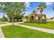 Single-story home with manicured lawn, mulch beds, and stately palms at 3302 Granite Ridge Loop, Land O Lakes, FL 34638