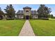 Elegant home with manicured lawn, stone façade, and a paver walkway at 3302 Granite Ridge Loop, Land O Lakes, FL 34638