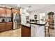Kitchen with dark wood cabinets, stainless steel appliances, and black countertop island at 3302 Granite Ridge Loop, Land O Lakes, FL 34638